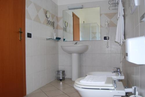 ein Badezimmer mit einem WC, einem Waschbecken und einem Spiegel in der Unterkunft Telma Hotel in Terracina
