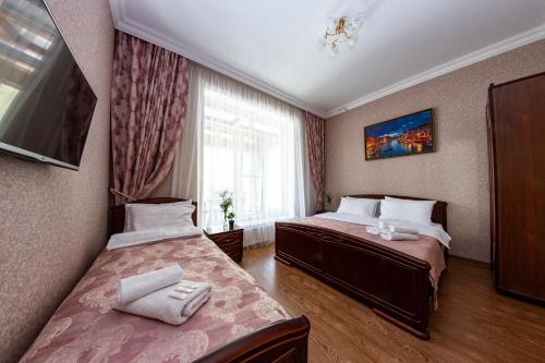 Habitación de hotel con 2 camas y ventana en Mountain Saniba Eco Hotel en Staraya Saniba