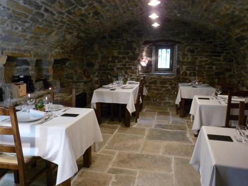 une salle à manger avec des tables et des nappes blanches dans l'établissement Hotel Posada Al Vent - Adults Only, à Coscojuela de Sobrarbe