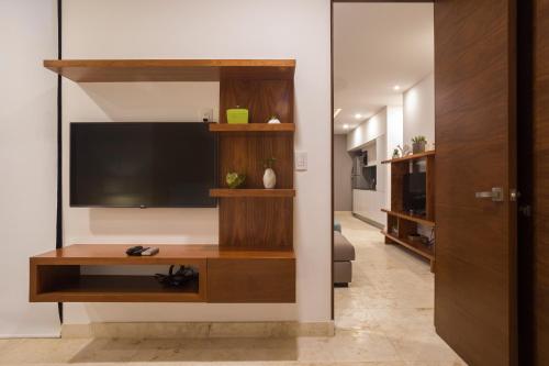 un soggiorno con TV a schermo piatto a parete di Lovely 1 Bedroom Condo with plunge pool In Bahia Principe Golf Resort ad Akumal