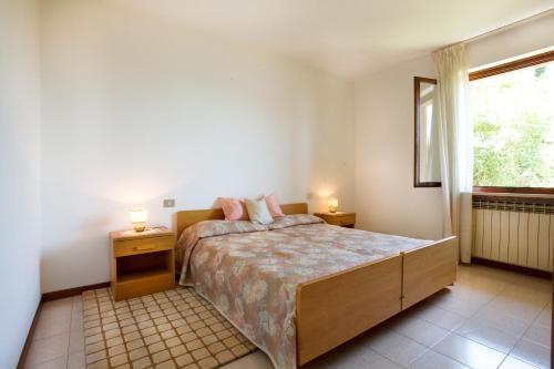 a bedroom with a bed with two night stands and a window at Residence le Balze in Malcesine