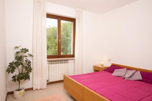 a bedroom with a purple bed and a window at Residence le Balze in Malcesine