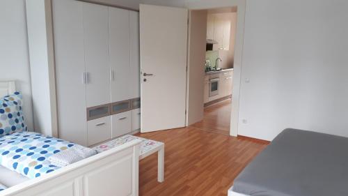 a white room with a bed and a kitchen at City Appartment Orlitsch in Klagenfurt
