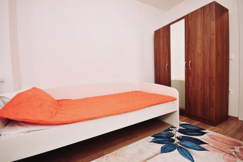 um quarto com uma cama com um colchão laranja em Skopje Apartments near central Bus Station JK APARTMENTS em Skopje