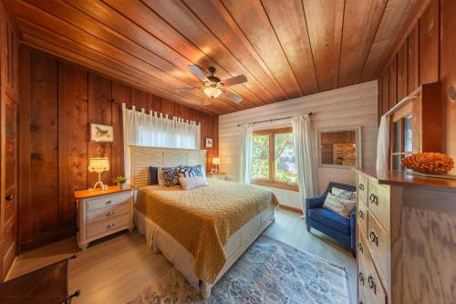 a bedroom with a bed and a wooden ceiling at Redwood Hollow Cottages in San Diego