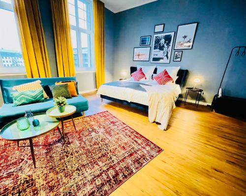 a bedroom with a bed and a couch and a rug at Klassen Stay - Exklusive Altbau Apartments - Zentral - Rheinnähe in Koblenz