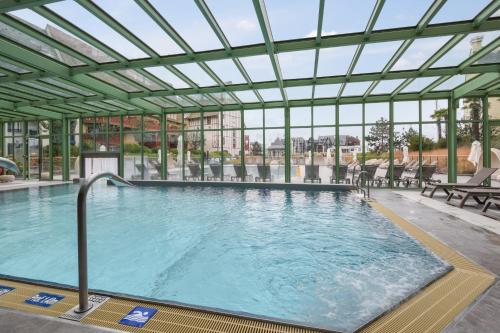 uma grande piscina com tecto de vidro em Résidence Pierre & Vacances Premium Presqu'Ile de la Touques em Deauville