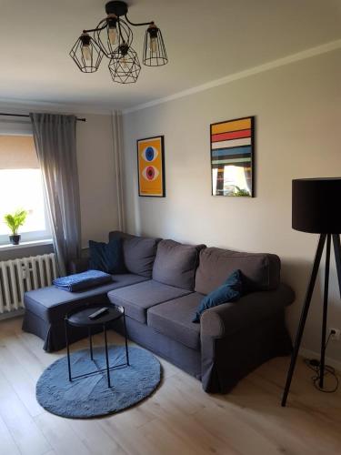 uma sala de estar com um sofá e uma mesa em Apartament Monika em Klodzko