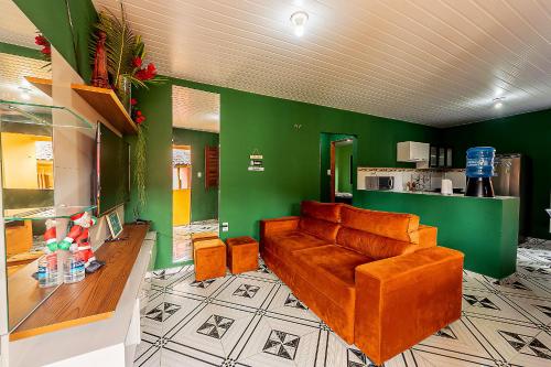 a living room with a brown couch and green walls at Huisje Van Kuringen in Guaramiranga