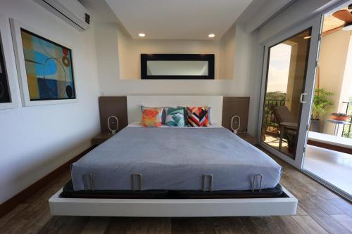 a bedroom with a bed in a room with a balcony at Brandnew Luxury 2Bdr condo✰Stunning view✰Fast wifi in Tamarindo
