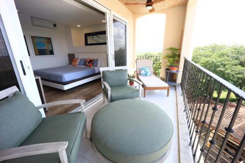 a porch with a couch and chairs on a balcony at Brandnew Luxury 2Bdr condo✰Stunning view✰Fast wifi in Tamarindo