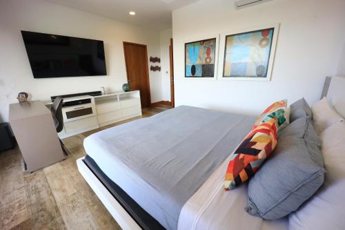 a bedroom with a large bed and a flat screen tv at Brandnew Luxury 2Bdr condo✰Stunning view✰Fast wifi in Tamarindo