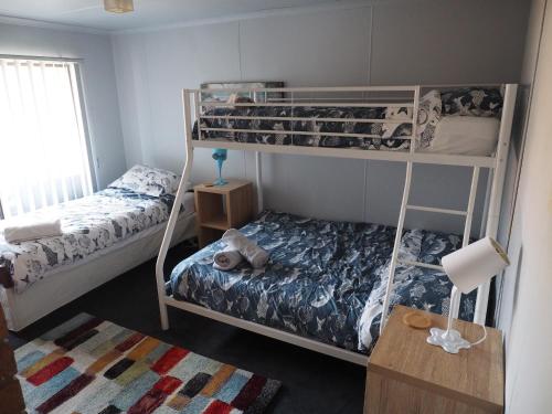 a bedroom with two bunk beds and a table at Port Relaxation in Portarlington