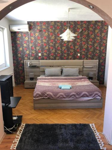 a bedroom with a bed and a wall with flowers at Square Vanilla Downtown in Skopje