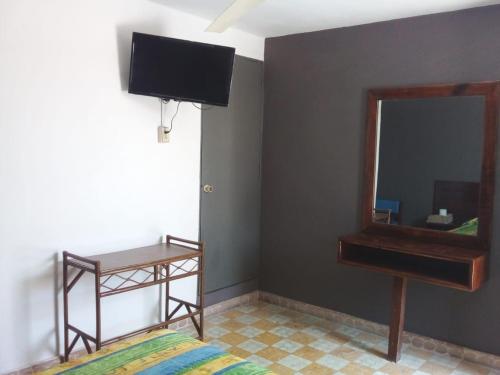 ein Schlafzimmer mit einem Spiegel, einem Bett und einem Schreibtisch in der Unterkunft Hotel Verasol in Veracruz