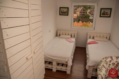 a room with two beds and a wall at Guesthouse Edelnice in Gornja Trepča