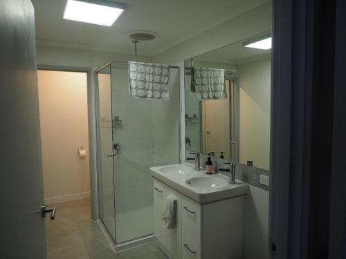 a bathroom with a sink and a shower and a mirror at Port Relaxation in Portarlington