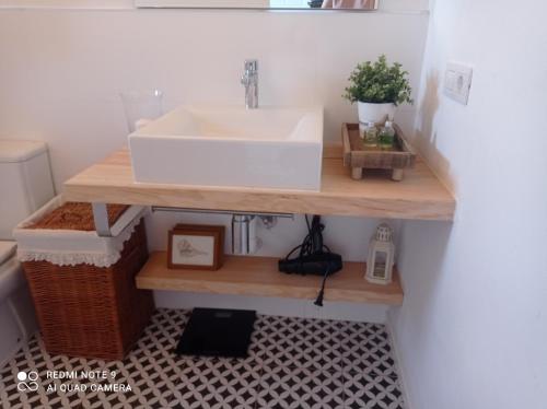 a bathroom with a sink on a wooden shelf at Casa Chano Estudio confortable Tenerife in Icod de los Vinos