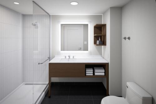 y baño con lavabo, ducha y espejo. en Staybridge Suites - Colorado Springs NE Powers, an IHG Hotel en Colorado Springs