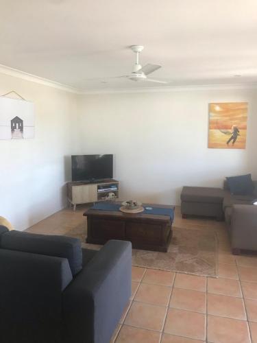a living room with a couch and a coffee table at Laudable Lizzie in Sawtell
