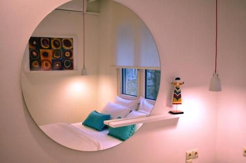 een kamer met een spiegel en een bed met een raam bij Gallery Suites Parga in Parga