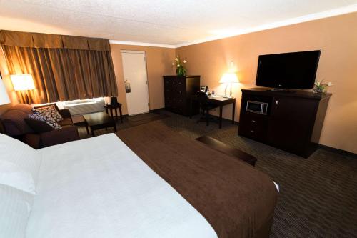 a hotel room with a bed and a flat screen tv at Best Western Plus Dryden Hotel and Conference Centre in Dryden