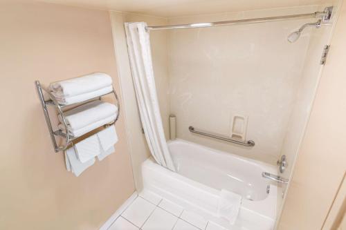 a bathroom with a tub and a shower with towels at Best Western Plus Dryden Hotel and Conference Centre in Dryden