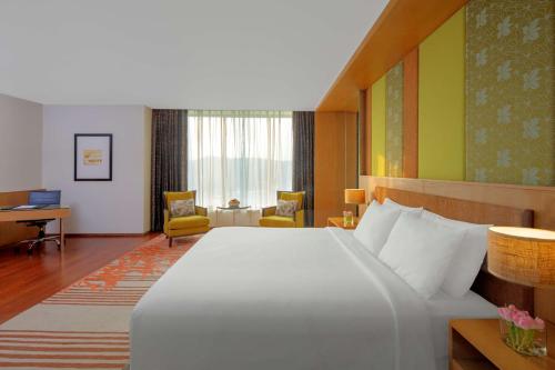 a hotel room with a large bed and a desk at Radisson Blu Hotel Guwahati in Guwahati