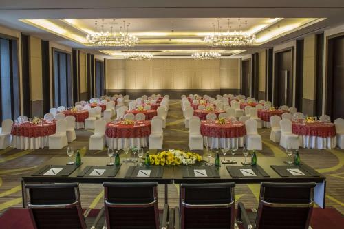 a banquet hall with tables and chairs and chandeliers at Radisson Blu Hotel Guwahati in Guwahati