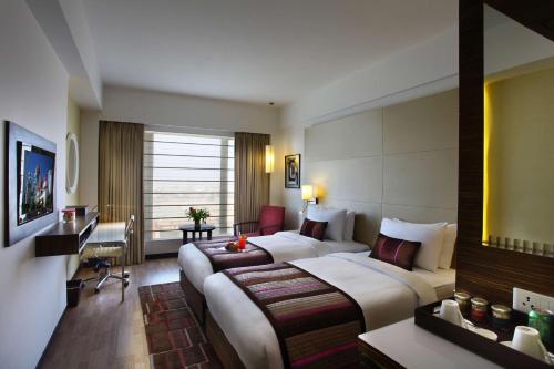 a hotel room with two beds and a television at Park Plaza Shahdara in New Delhi