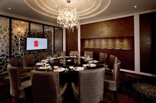 a dining room with a table and chairs and a chandelier at Park Plaza Beijing Science Park in Beijing