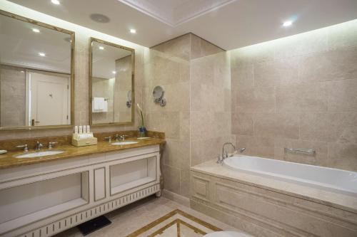 
a bath tub sitting next to a sink in a bathroom at Radisson Blu Resort Phu Quoc in Phú Quốc
