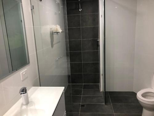 a bathroom with a shower with a toilet and a sink at Sebel 302 - Deluxe Apartment in Maroochydore