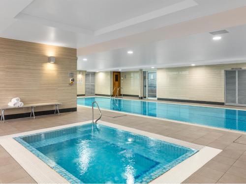 a large swimming pool in a hotel room with a pool at Meriton Suites World Tower, Sydney in Sydney