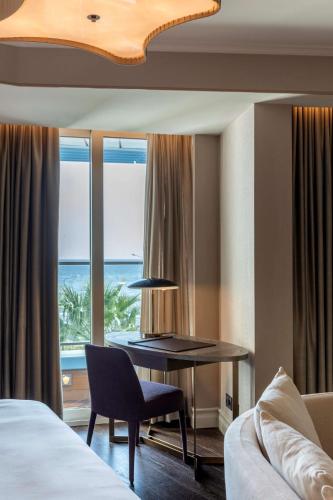 a hotel room with a desk and a view of the ocean at Radisson Blu Hotel Istanbul Ottomare in Istanbul