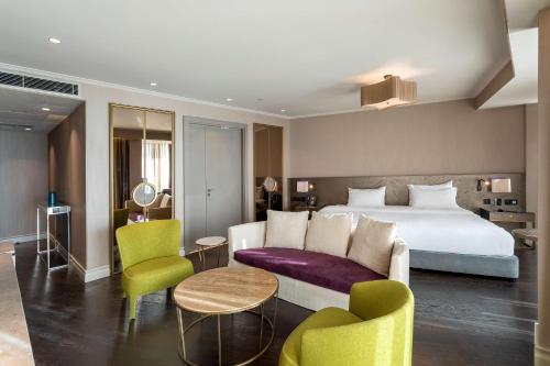 a hotel room with a bed and a couch and chairs at Radisson Blu Hotel Istanbul Ottomare in Istanbul