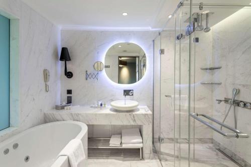 a bathroom with a tub and a sink and a shower at Radisson Blu Hotel Istanbul Ottomare in Istanbul