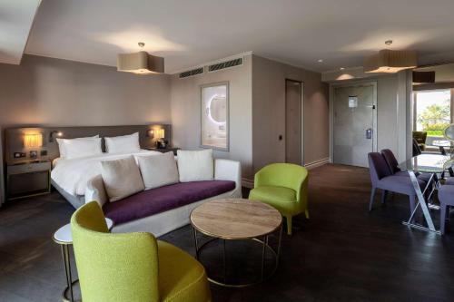 a hotel room with a bed and a couch and chairs at Radisson Blu Hotel Istanbul Ottomare in Istanbul