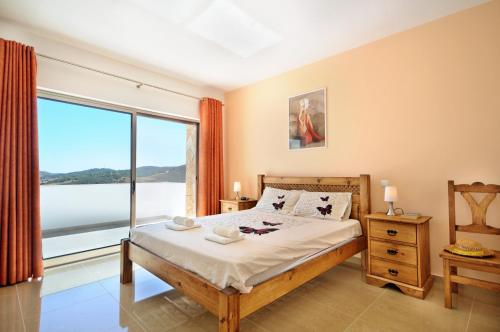 a bedroom with a bed and a large window at Casa da Ribeira in Silves