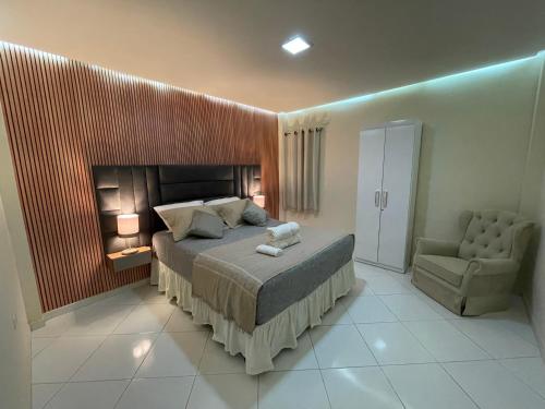 a bedroom with a bed and a chair at Apartamento encantador em Seabra in Seabra