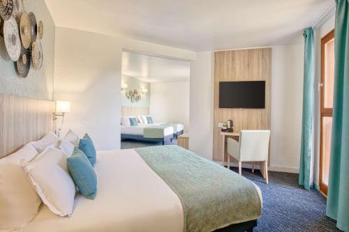 a hotel room with a bed and a tv at Les Hameaux De Lozere Sure Hotel Collection by Best Western in Fournels