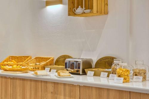a bakery counter with bread and other food items at Les Hameaux De Lozere Sure Hotel Collection by Best Western in Fournels
