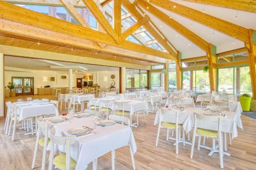 a banquet hall with white tables and chairs at Les Hameaux De Lozere Sure Hotel Collection by Best Western in Fournels