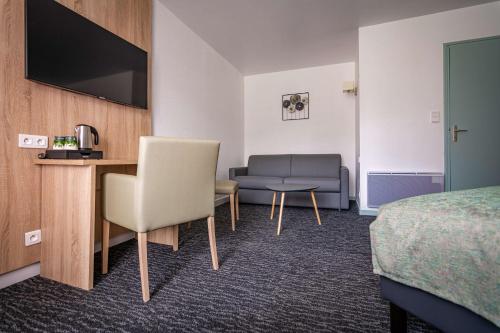 a hotel room with a bed and a couch at Les Hameaux De Lozere Sure Hotel Collection by Best Western in Fournels