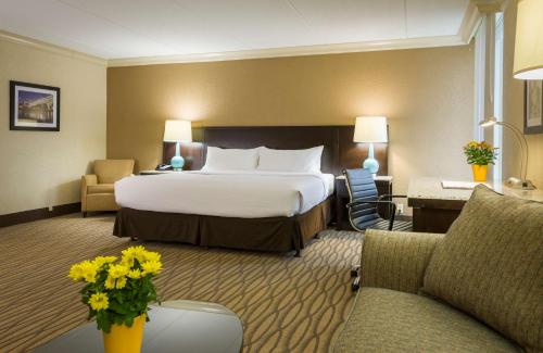a hotel room with a large bed and chairs at Best Western Plus Strongsville Cleveland in Strongsville