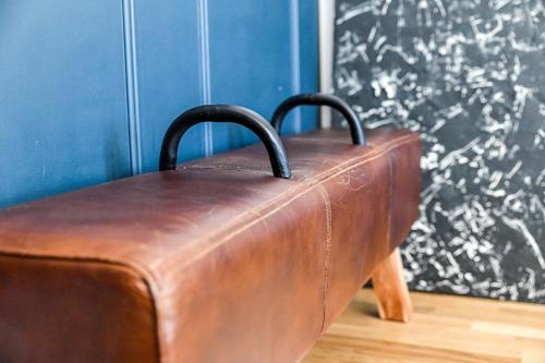 a brown leather suitcase sitting against a blue wall at La Maison de Reina in Troyes