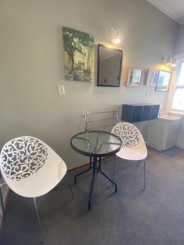 a room with two chairs and a glass table at National Park Alpine Lodge in National Park