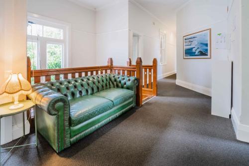 The Oriental Hotel في نيوكاسل: غرفة معيشة مع أريكة خضراء وطاولة