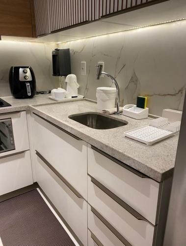 a kitchen with a sink and a counter top at Buenos Ayres Flats, Cabo Branco 1qto cozinha completa in João Pessoa