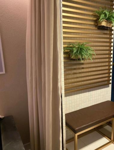 a window with a curtain and a bench in a room at Buenos Ayres Flats, Cabo Branco 1qto cozinha completa in João Pessoa